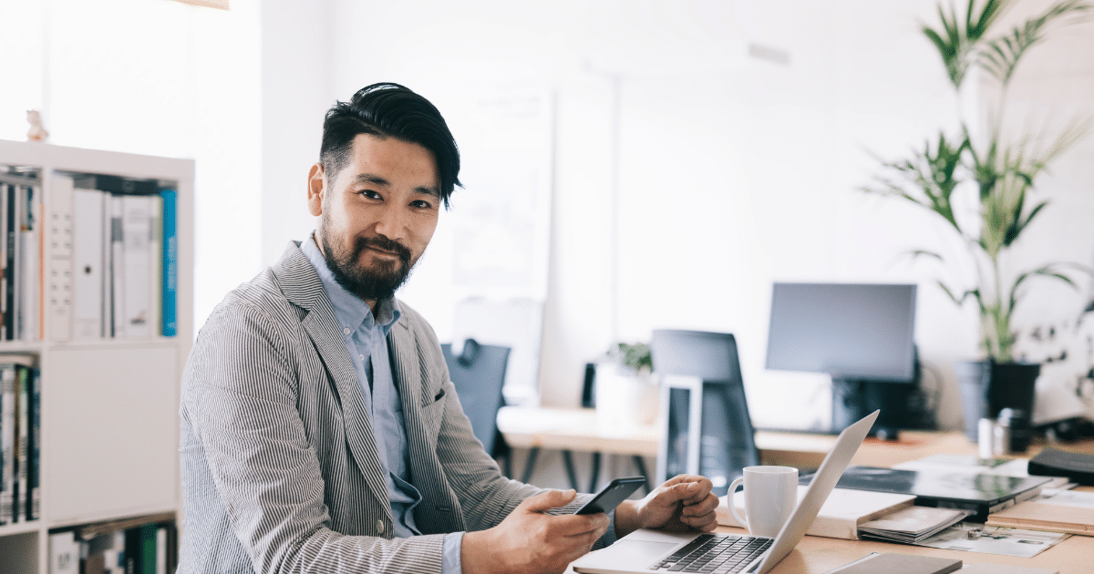 Business professional using a laptop and smartphone in a modern office, exploring unsecured small business line of credit options.
