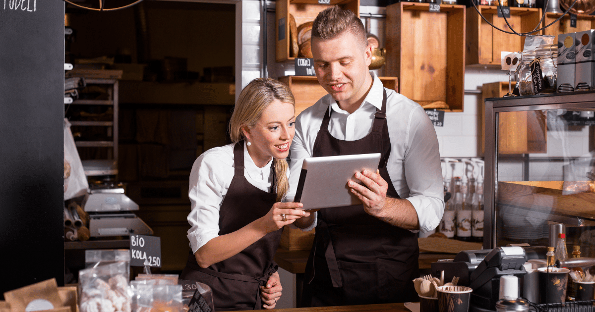 Business owners discussing financial solutions with a tablet, highlighting small business line of credit options.