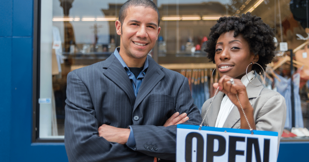Business owners showcasing an 'OPEN' sign, representing unsecured lines of credit and business loans for financial growth.