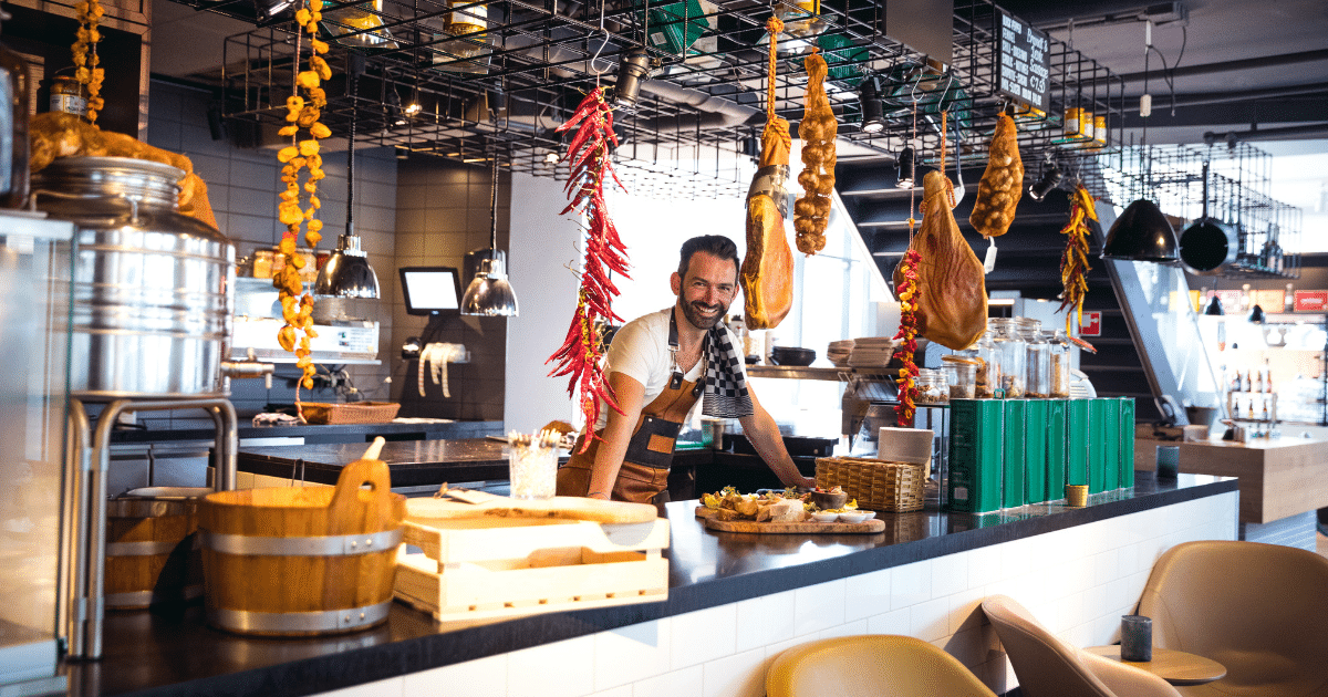 Small business owner in a modern restaurant, showcasing food and decor, highlighting financing options for growth.