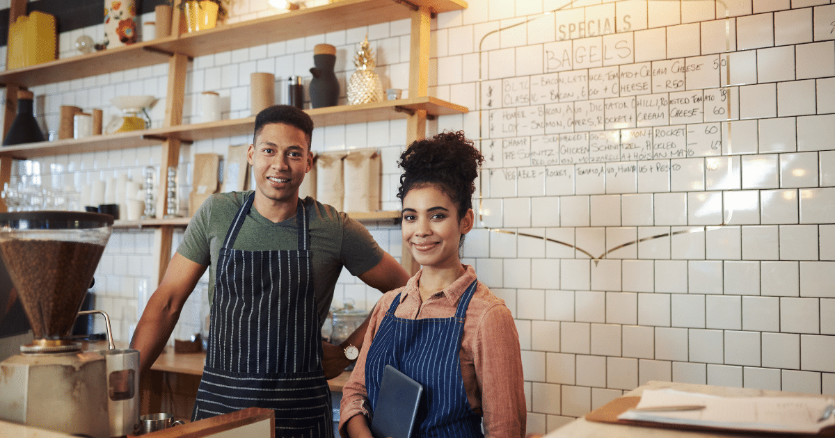Small business owners in a cafe setting, showcasing productivity tips and teamwork in a vibrant workspace.