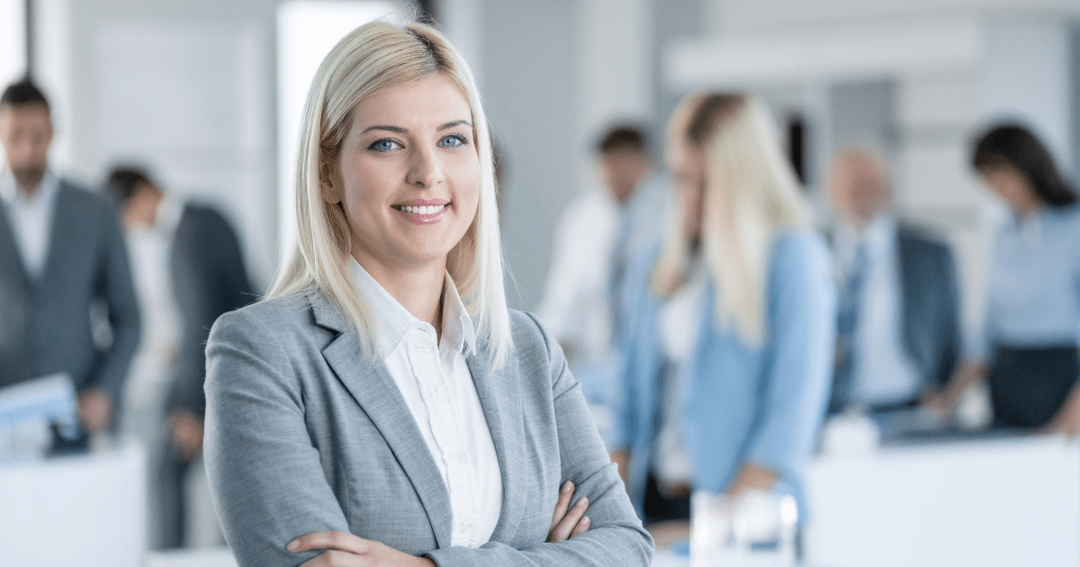 Professional woman smiling in a business setting, representing small business funding and growth opportunities.