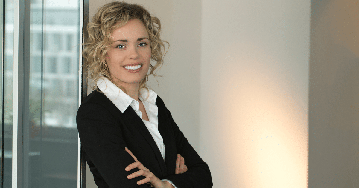 Professional woman smiling in business attire, representing B2B social media marketing strategies and engagement.