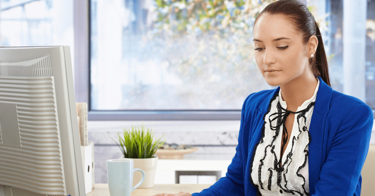 Businesswoman focused on computer security strategies for small business growth in a modern office setting.