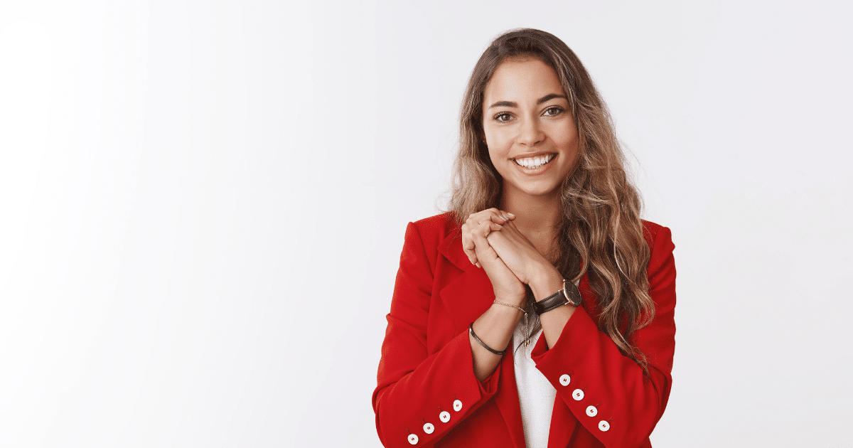 Smiling woman in a red blazer representing effective customer engagement strategies for small businesses.