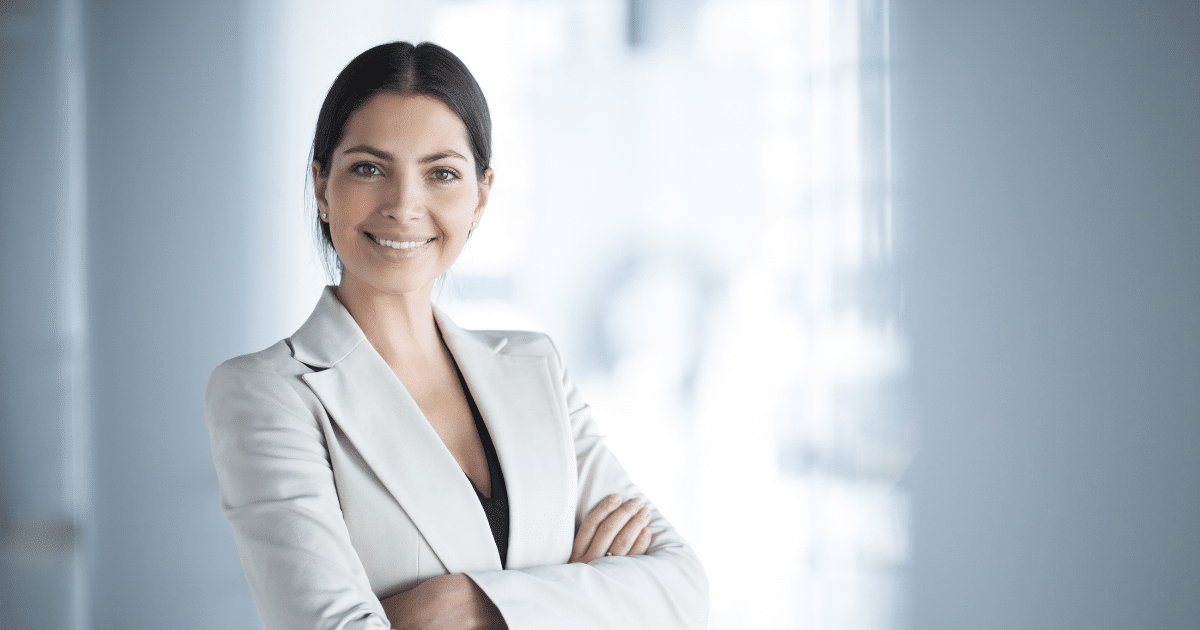 Professional woman smiling in a business setting, representing technology's role in driving economic growth for small businesses.
