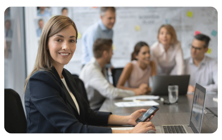 Business professional using a smartphone in a meeting, highlighting strategic credit card benefits for growth.
